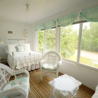 One of the rooms overlooks the front lawn and boasts ample seating and a plush bed