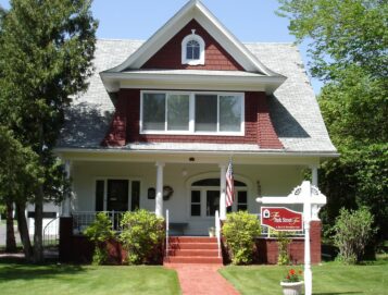 The front of the inn shows a landscaped lawn and red Victorian exterior.