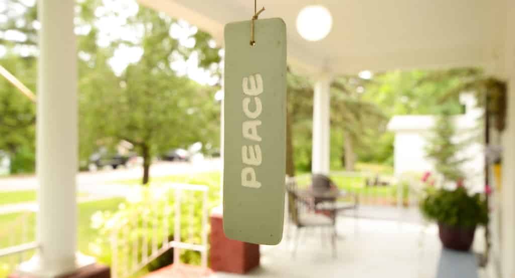 A room tag reading 'Peace' dangles in front of the porch