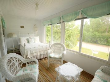 One of the rooms overlooks the front lawn and boasts ample seating and a plush bed